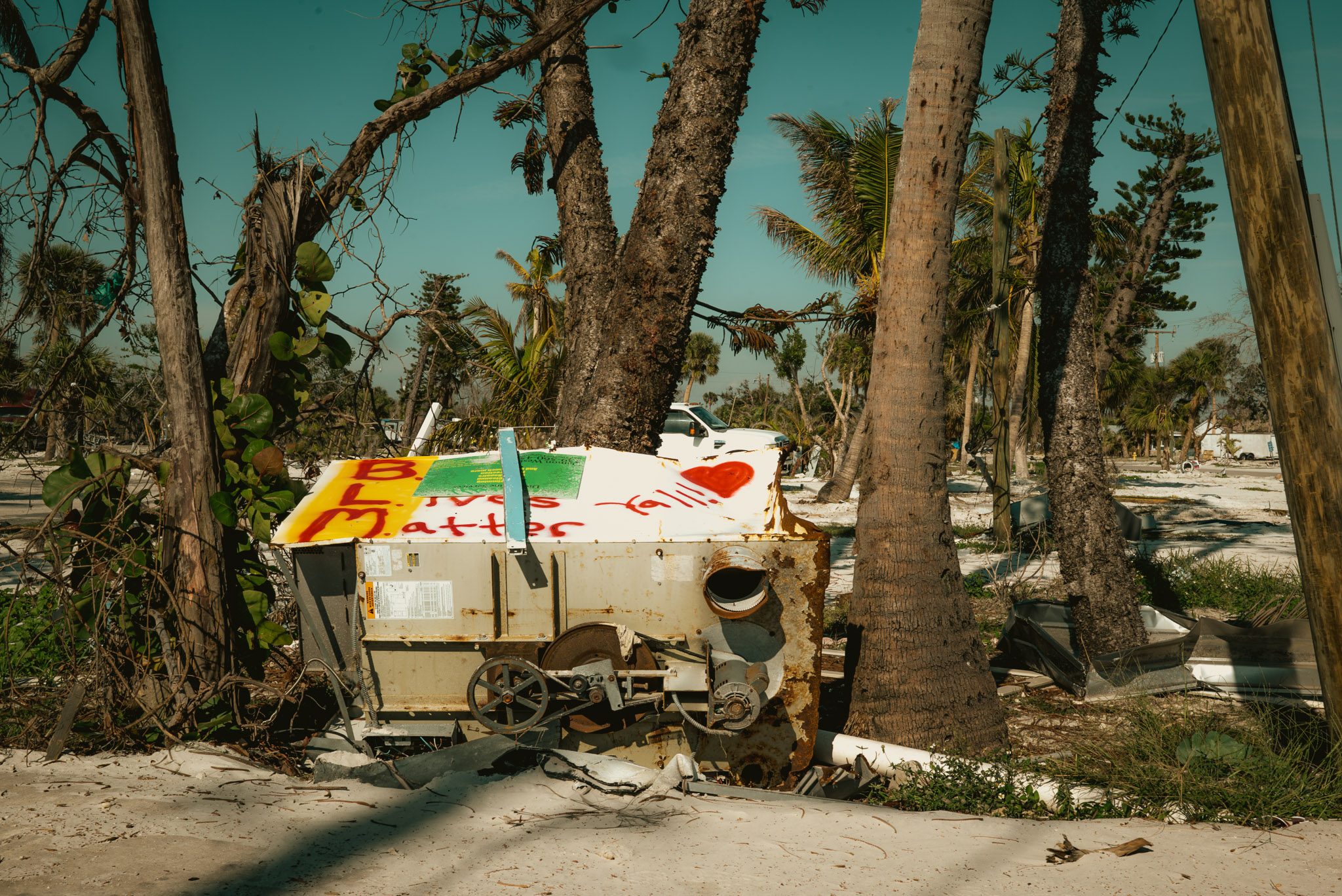 People gather outside a storm-damaged home in Fort Myers.
