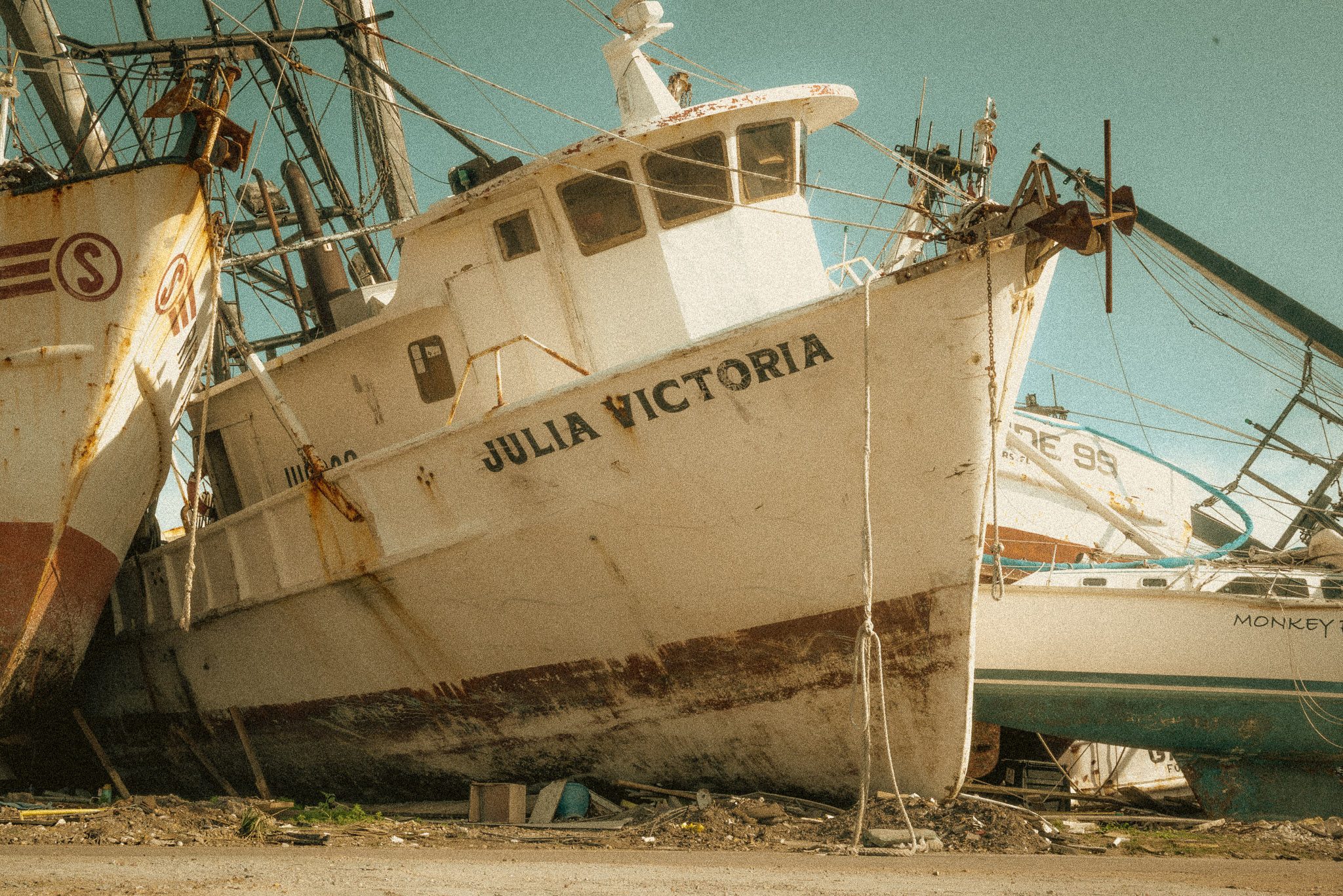 A small blue Smurf figurine lies in hurricane rubble.