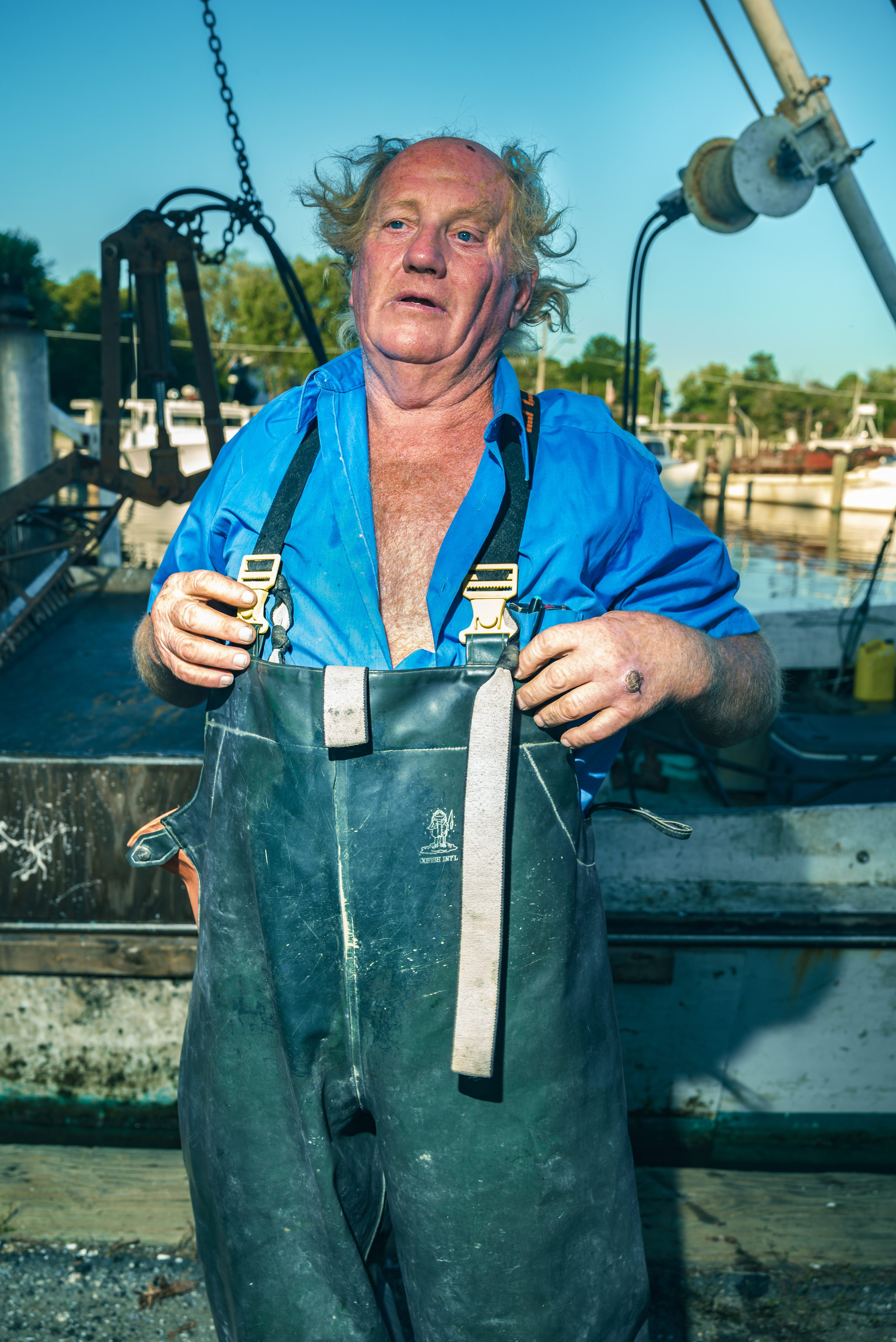 A waterman stands for a portrait on the deck of his boat.