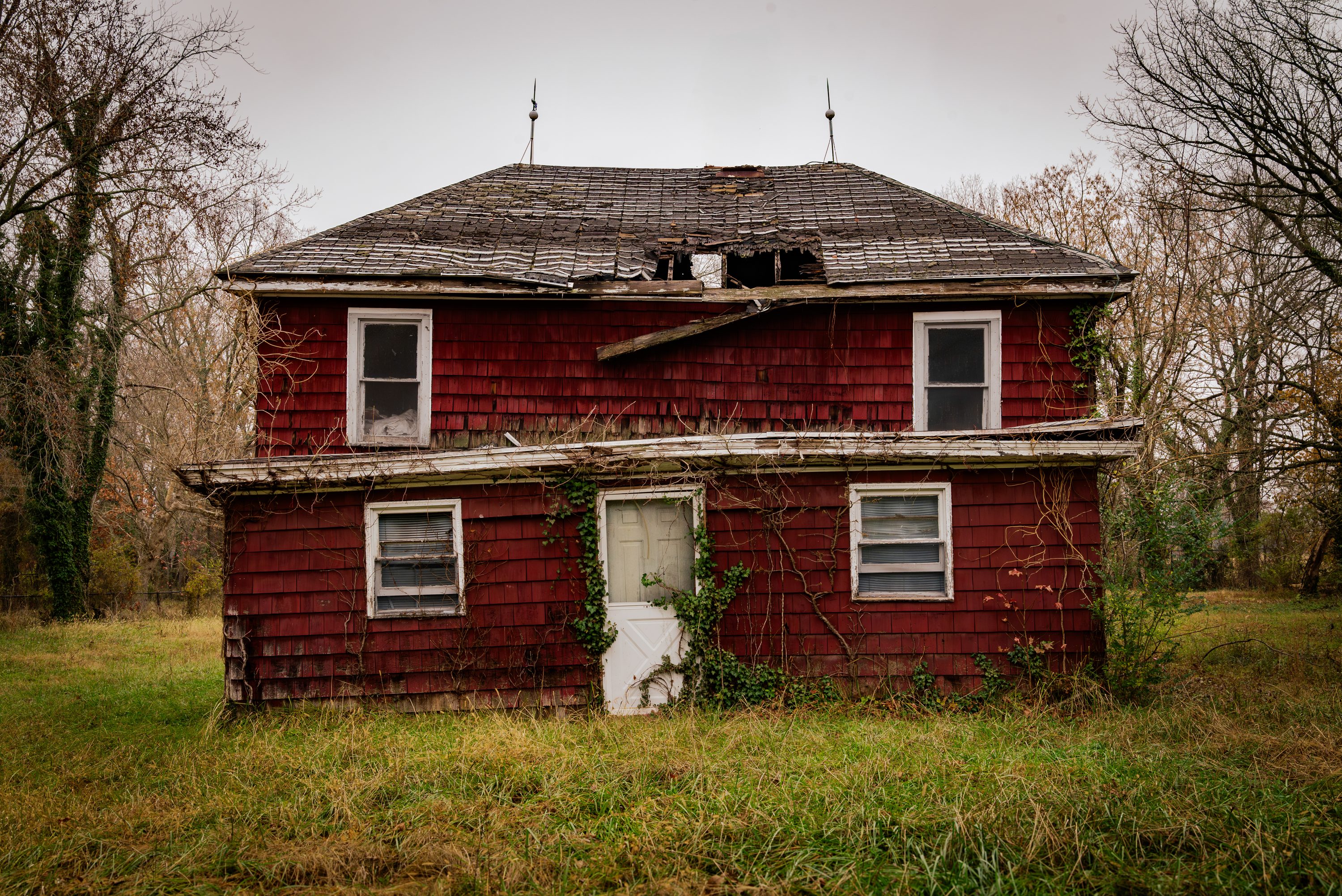 A red farmhouse stands at the edge of a field in Unionville.