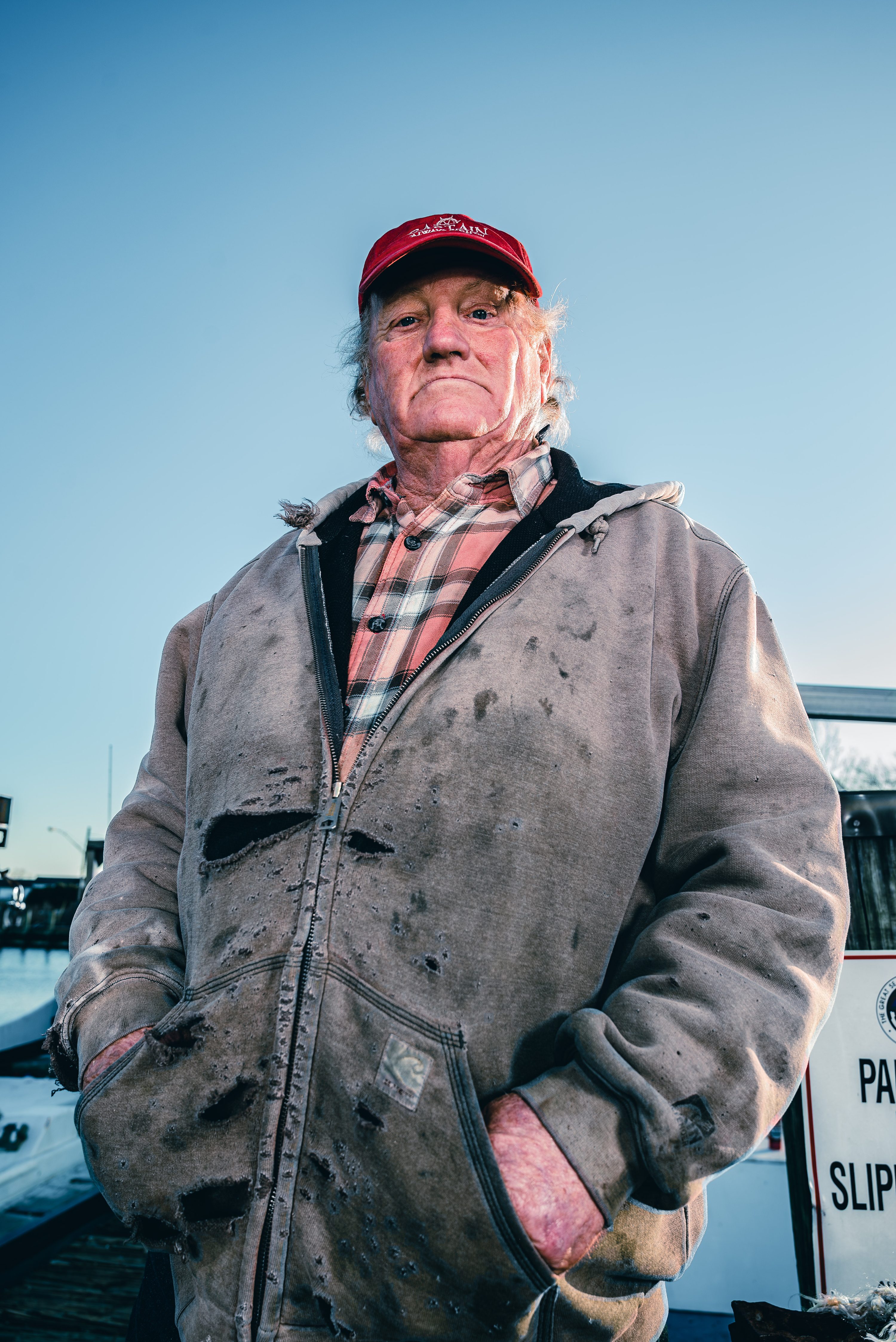A waterman's torn, work-stained jacket, hands in the pockets.