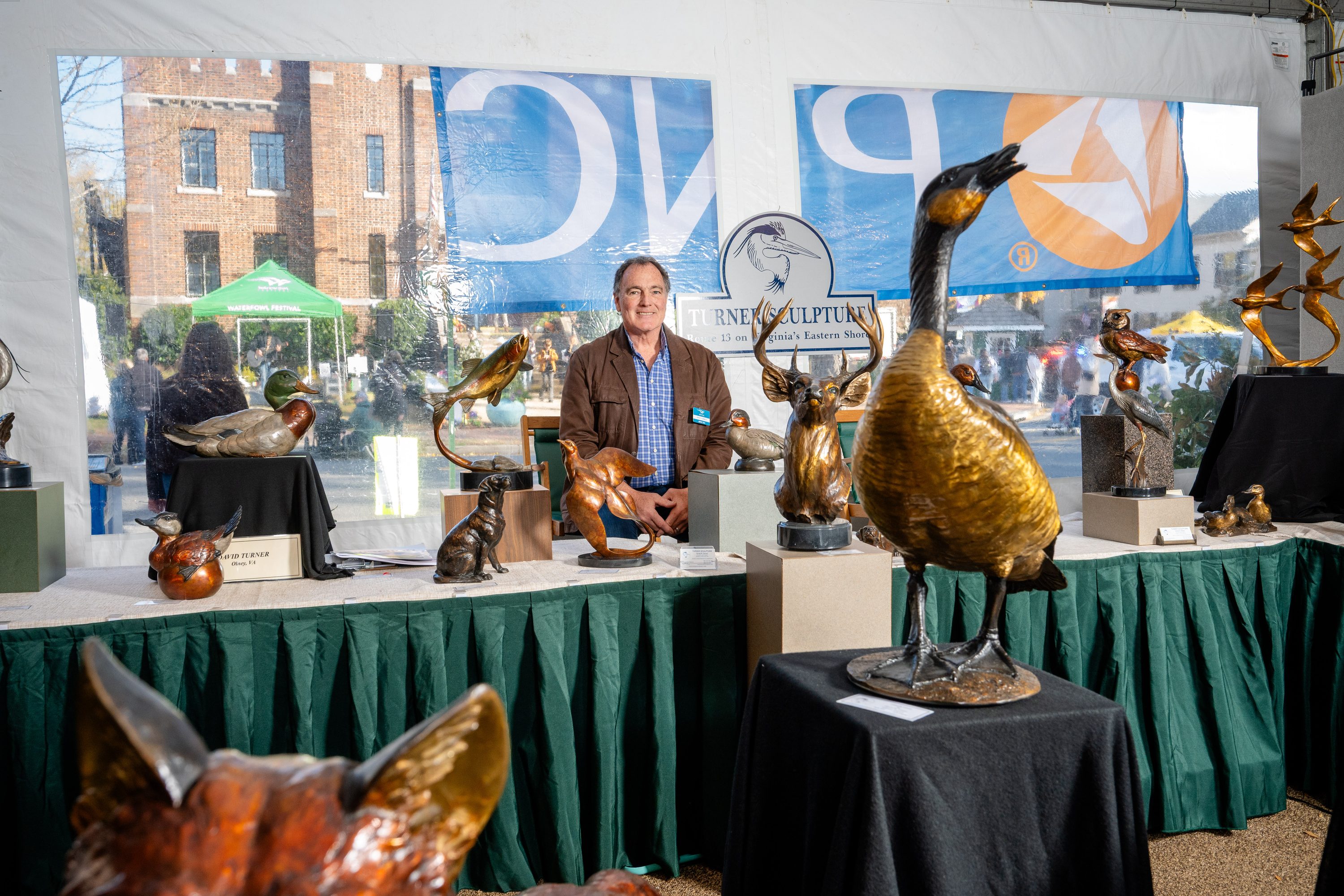 Visitors view framed waterfowl artwork on a gallery wall at the Waterfowl Festival.