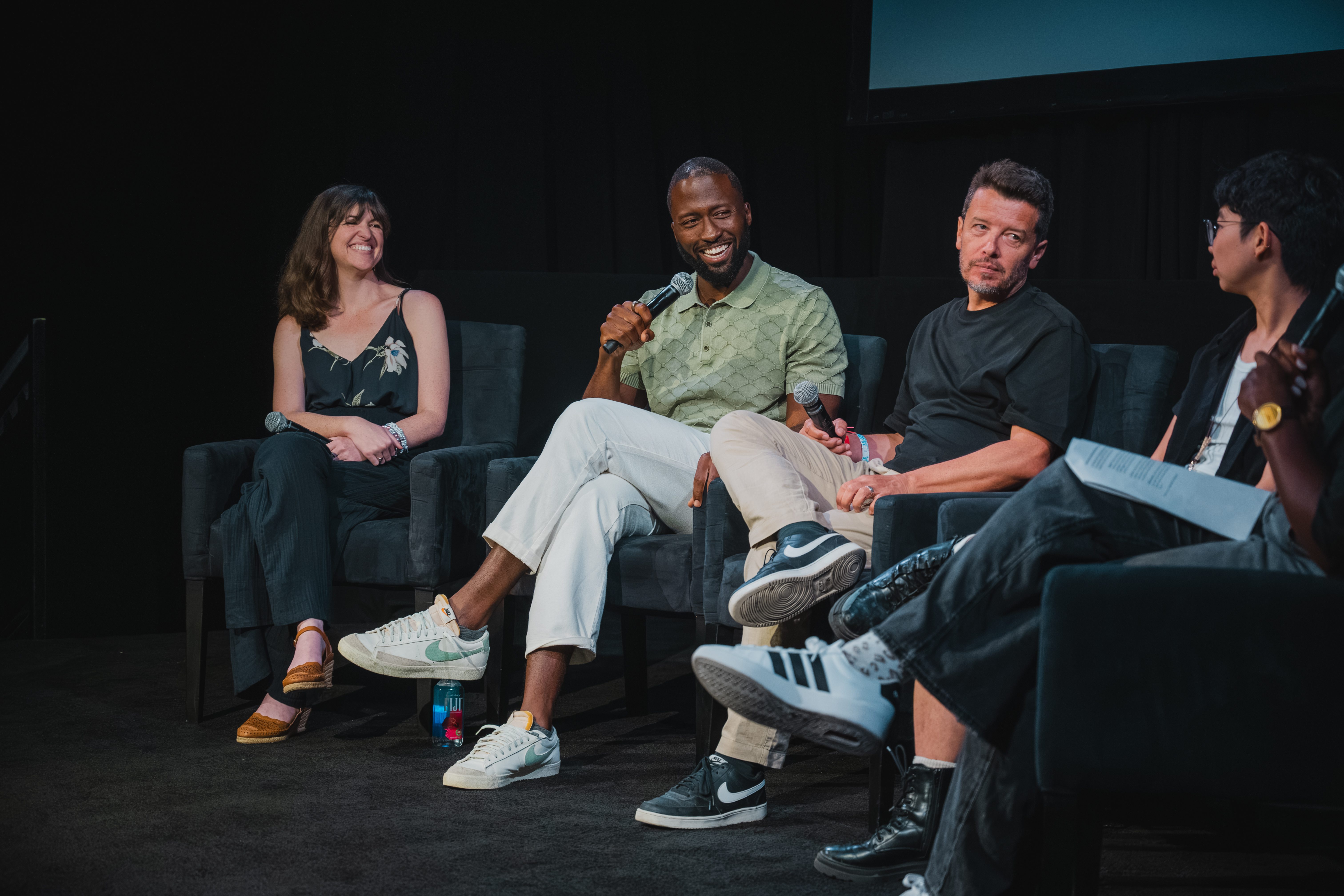Panelists share a laugh on stage during a festival talk.