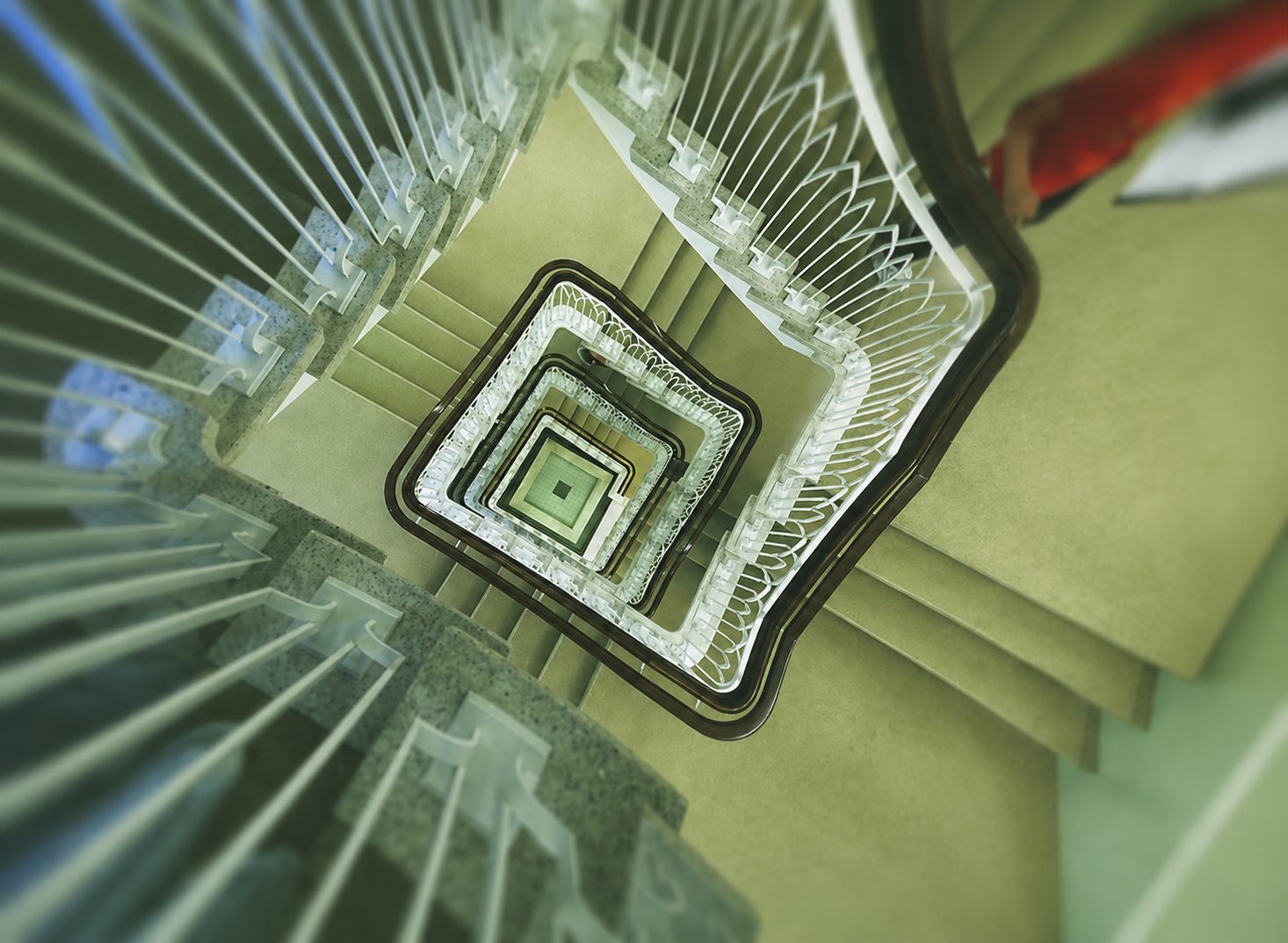 A spiral staircase curves upward in soft green tones.