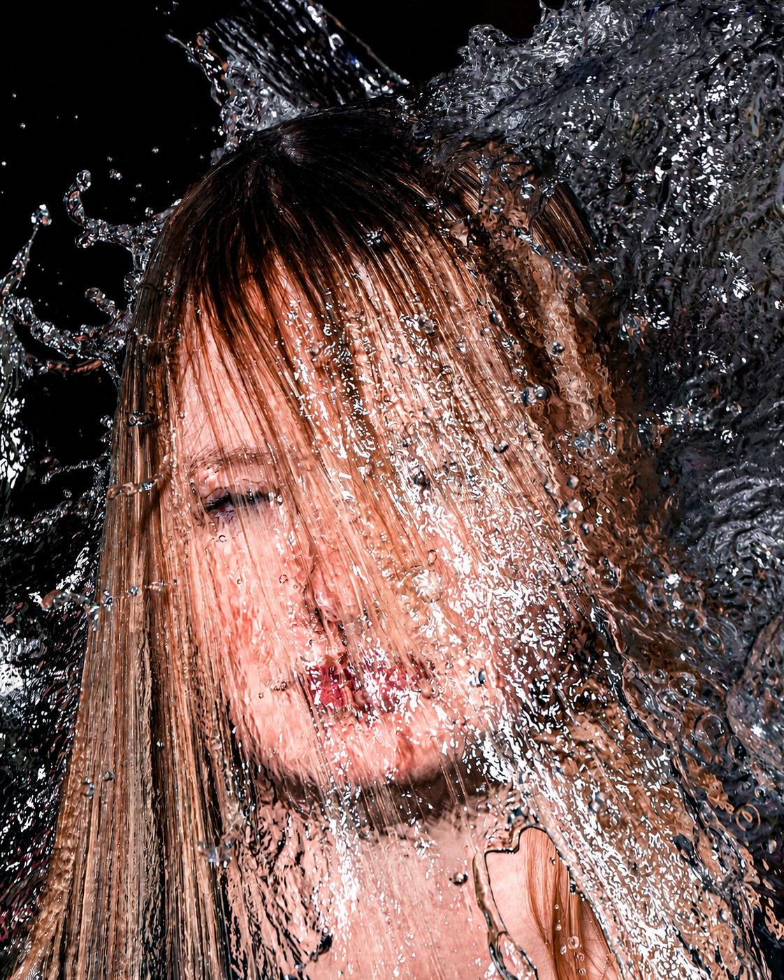 A sheet of water hangs mid-air during an ice-bucket pour.