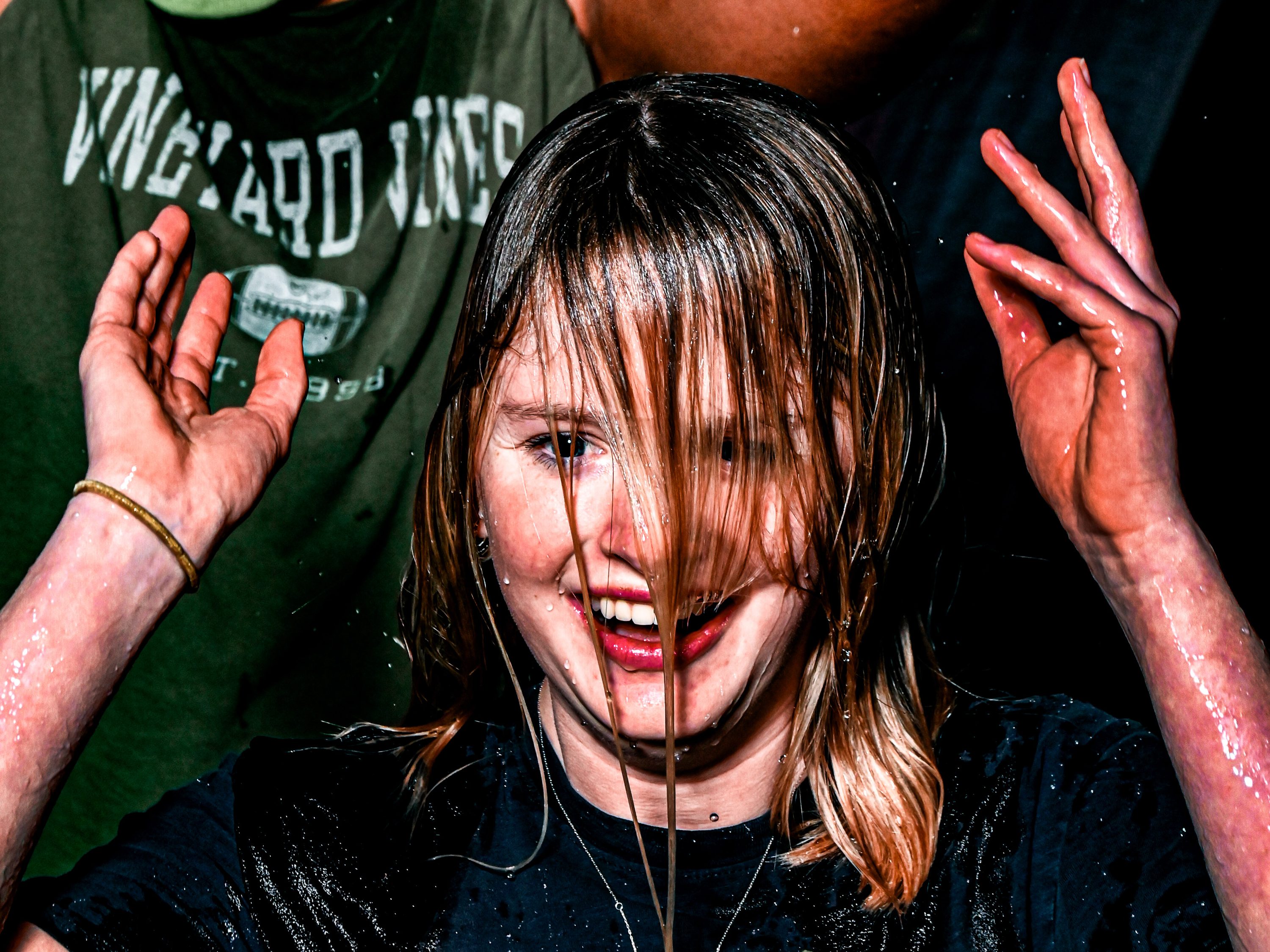 A drenched figure reacts just after the ice-bucket pour.