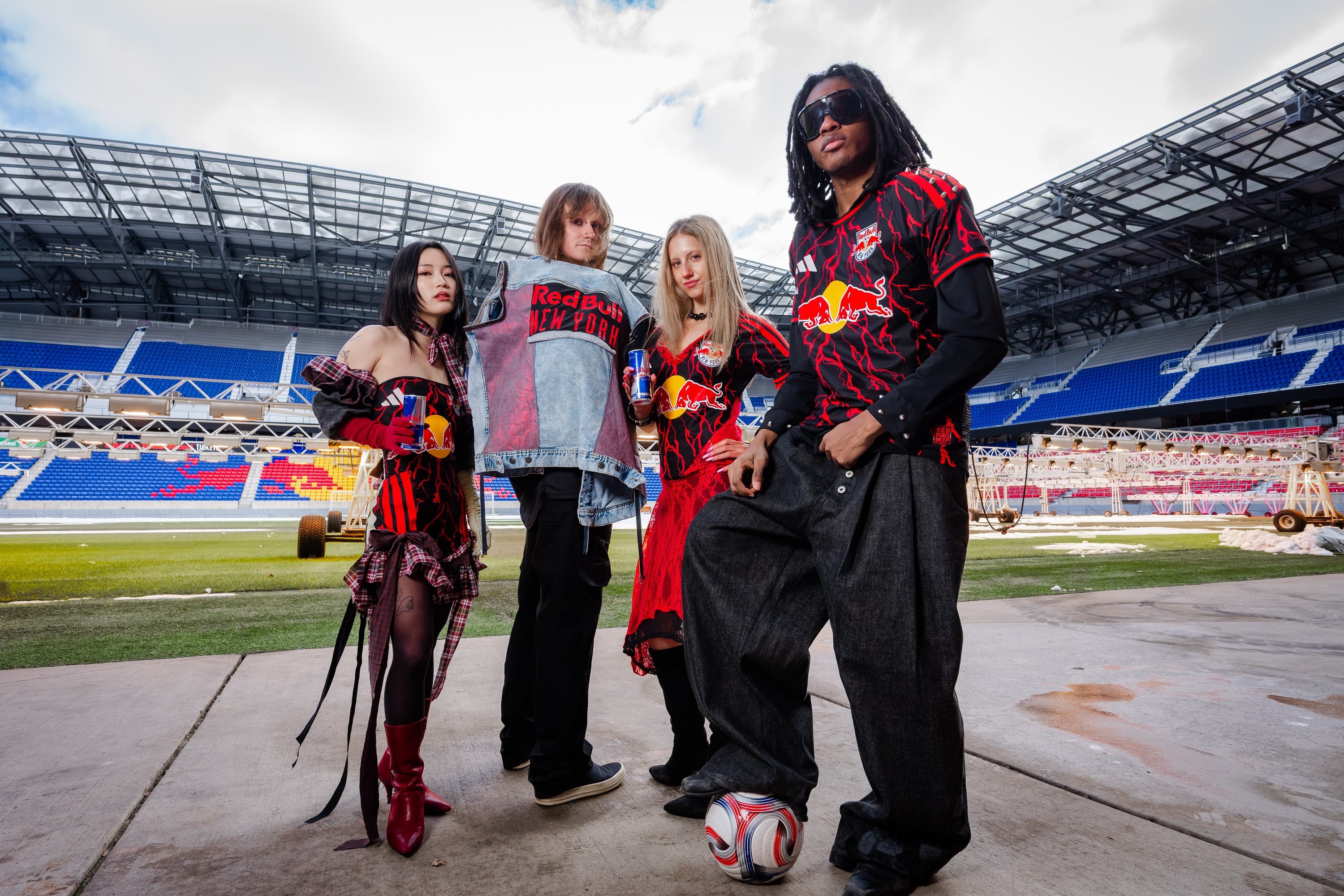 A styled group in Red Bull kits stands on the stadium pitch.