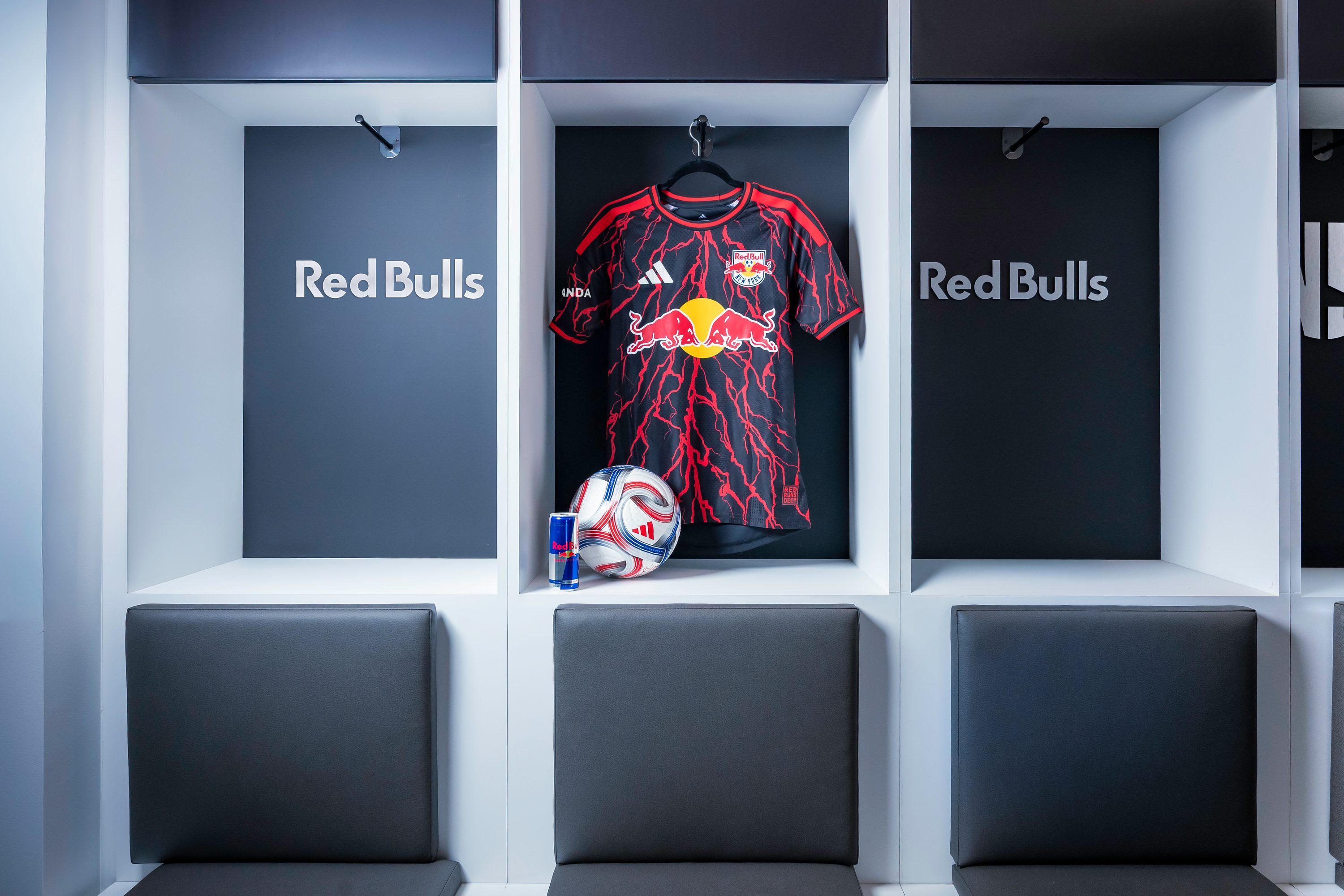 A Red Bull jersey and match ball displayed in a locker cubby.