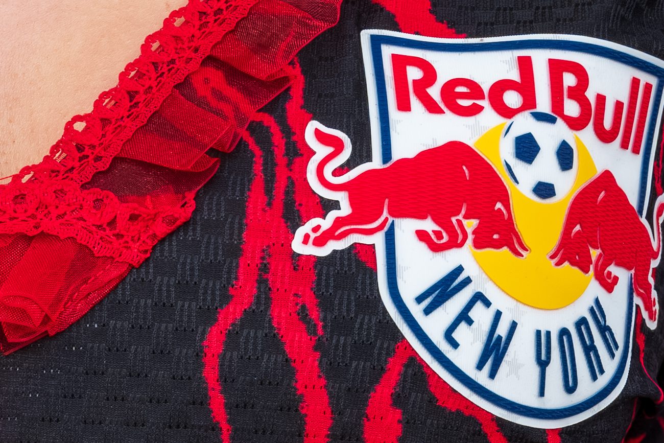 A Red Bull New York soccer crest on a black jersey trimmed with red lace.